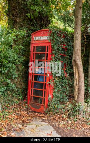 Frau in einem roten traditionelle Telefonzelle in England gefangen Stockfoto