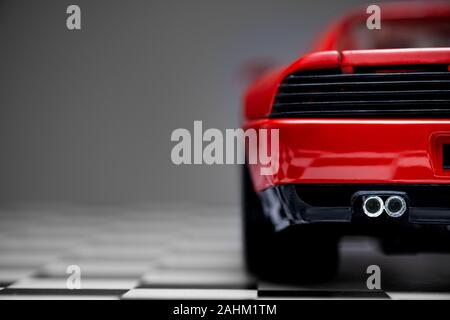 Izmir, Türkei - 27. Dezember 2019. Rückansicht eines Roten Spielzeug Ferrari 348 TB Sport Auto close up Produkt Schuß auf einem karierten Boden und grauen Hintergrund. Stockfoto