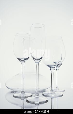 Glaswaren Auswahl mit Wein, Sekt, liquour Gläser und Dekanter auf dem hellen Hintergrund.. Feine cristal Glaswaren Konzept. Vertikal, kalten Ton in leichte Erkältung toning Stockfoto