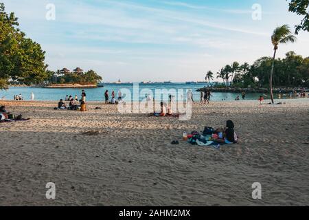 Badegäste am Abend entspannen Sie bei Man-made Palawan Beach, Insel Sentosa, Singapur Stockfoto