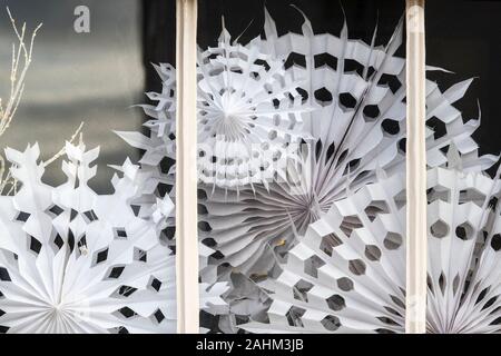 Weihnachten Papier Schneeflocke Dekorationen in einem Haus Fenster. Chelsea, London, England Stockfoto