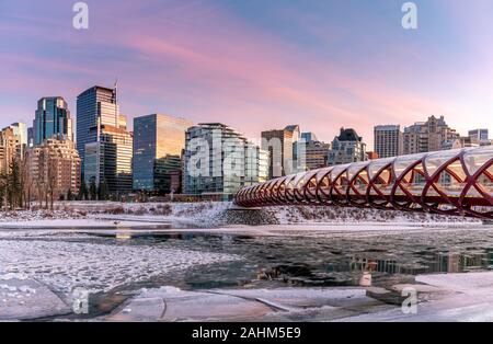 Blick auf die Skyline von Calgary an einem kalten Wintertag. Bow River und der Peace Bridge sind sichtbar im Bild. Bürotürme in den Kern der Innenstadt sind auch. Stockfoto