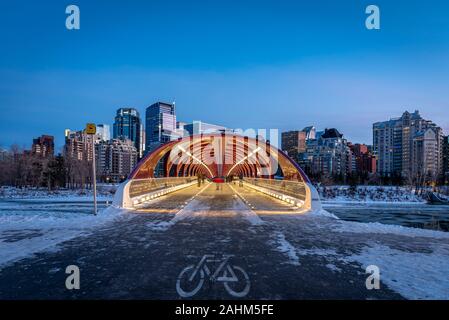 Blick auf die Skyline von Calgary an einem kalten Wintertag. Bow River und der Peace Bridge sind sichtbar im Bild. Bürotürme in den Kern der Innenstadt sind auch. Stockfoto