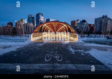 Blick auf die Skyline von Calgary an einem kalten Wintertag. Bow River und der Peace Bridge sind sichtbar im Bild. Bürotürme in den Kern der Innenstadt sind auch. Stockfoto