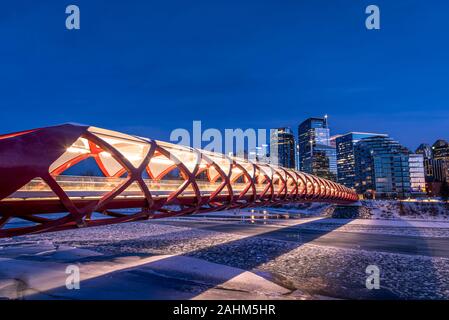 Blick auf die Skyline von Calgary an einem kalten Wintertag. Bow River und der Peace Bridge sind sichtbar im Bild. Bürotürme in den Kern der Innenstadt sind auch. Stockfoto