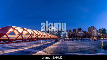 Blick auf die Skyline von Calgary an einem kalten Wintertag. Bow River und der Peace Bridge sind sichtbar im Bild. Bürotürme in den Kern der Innenstadt sind auch. Stockfoto