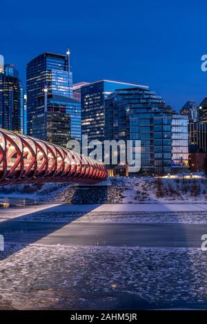 Blick auf die Skyline von Calgary an einem kalten Wintertag. Bow River und der Peace Bridge sind sichtbar im Bild. Bürotürme in den Kern der Innenstadt sind auch. Stockfoto