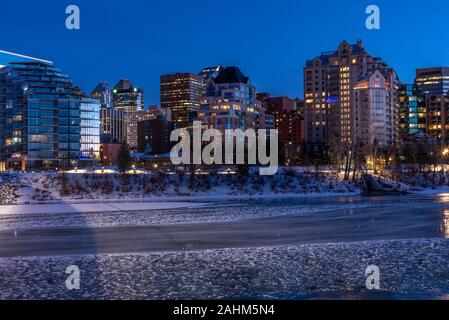 Blick auf die Skyline von Calgary an einem kalten Wintertag. Bow River und der Peace Bridge sind sichtbar im Bild. Bürotürme in den Kern der Innenstadt sind auch. Stockfoto