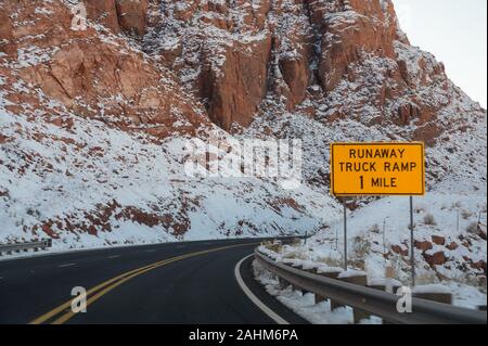 Runaway Lkw Rampe neben eine asphaltierte Straße durch die roten Berge im Winter Stockfoto