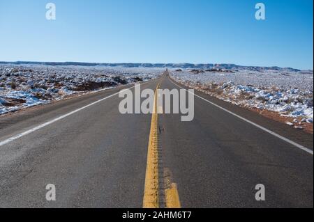 Asphaltierte Straße durch die verschneite Winterlandschaft in Arizona Stockfoto