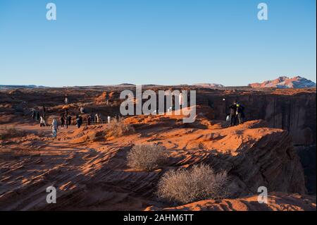 Menschen - Touristen und Fotografen - erleben Sie den Sonnenaufgang im Horseshoe Bend in der Nähe von Page, Arizona Stockfoto