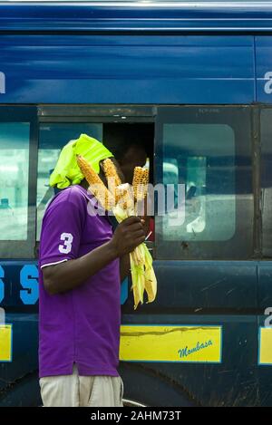 Einen kenianischen Mann verkaufen gerösteten Mais für Fahrgäste in einem Matatu Bus, Kenia, Ostafrika Stockfoto