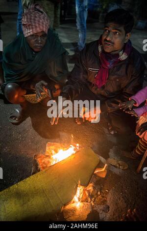 Kolkata. 30 Dez, 2019. Die Menschen drängen sich in ein Feuer durch einen kalten Winterabend in Kolkata, Indien am Dez. 30, 2019. Das India Meteorological Department (IMD) am Sonntag eine rot-codierten Warnung für Teile des Landes als eine kalte Welle zu fegen über das Land weiter. Beamte sagten eine Atempause von der Kälte von Dez. 31 bis Jan. 2 erwartet wurde. Credit: tumpa Mondal/Xinhua/Alamy leben Nachrichten Stockfoto