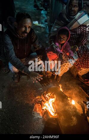 Kolkata. 30 Dez, 2019. Die Menschen drängen sich in ein Feuer durch einen kalten Winterabend in Kolkata, Indien am Dez. 30, 2019. Das India Meteorological Department (IMD) am Sonntag eine rot-codierten Warnung für Teile des Landes als eine kalte Welle zu fegen über das Land weiter. Beamte sagten eine Atempause von der Kälte von Dez. 31 bis Jan. 2 erwartet wurde. Credit: tumpa Mondal/Xinhua/Alamy leben Nachrichten Stockfoto