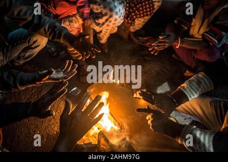 Kolkata. 30 Dez, 2019. Die Menschen drängen sich in ein Feuer durch einen kalten Winterabend in Kolkata, Indien am Dez. 30, 2019. Das India Meteorological Department (IMD) am Sonntag eine rot-codierten Warnung für Teile des Landes als eine kalte Welle zu fegen über das Land weiter. Beamte sagten eine Atempause von der Kälte von Dez. 31 bis Jan. 2 erwartet wurde. Credit: tumpa Mondal/Xinhua/Alamy leben Nachrichten Stockfoto