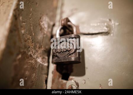 Schließen Sie herauf Bild mit einem metallischen Alte und Rost Schloss an der Tür eines kommunistischen Rumänien Securitate Gefängniszelle. Stockfoto