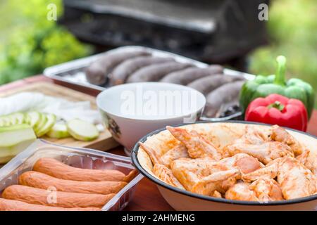 2. Wurst, Pudding und rohem Hühnerfleisch in den Gewürzen in einer Schüssel auf dem Tisch. Stockfoto