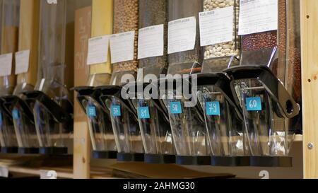 Shop ohne Verpackung moderne, gesunde Ernährung ein breites Sortiment von Getreide, Hülsenfrüchte, Nudeln, Trockenfrüchte, Nüsse, streuseln Streuer streuen auf dem Gießen Stockfoto