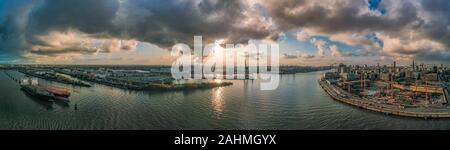 Panoramablick auf die drohne Luftaufnahme des Hamburger Hafens von hafencity vor Sonnenuntergang mit dramatischen stürmischen Wolken Stockfoto