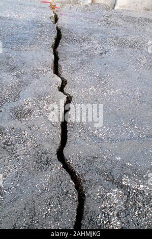 Einem langen gewundenen Riss in einer gepflasterten Straße. Stockfoto