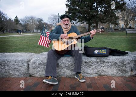 Ein Septuagenarian Vietnam Navy Veteran spielt seine Gitarre und singt auf der Thames Street in der Innenstadt von Newport, Rhode Island. Stockfoto