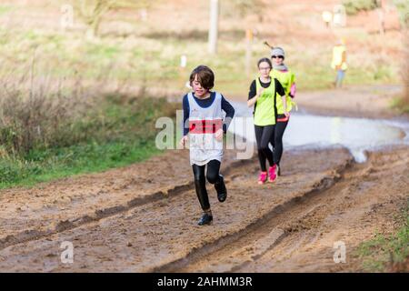 Sutton, Suffolk, VEREINIGTES KÖNIGREICH 15. Dezember 2019: A-Junioren unter 18 cross country running Rennen durch einen schlammigen Landschaft Kurs Stockfoto