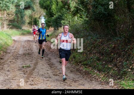 Sutton, Suffolk, VEREINIGTES KÖNIGREICH 15. Dezember 2019: eine Erwachsene über 18 cross country running Rennen durch einen schlammigen Landschaft Kurs Stockfoto