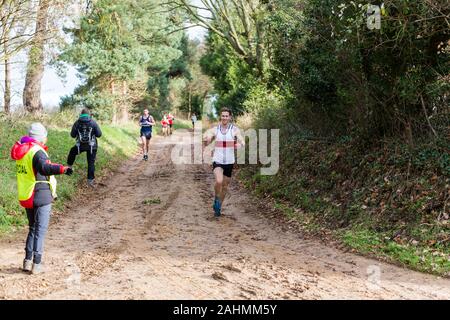 Sutton, Suffolk, VEREINIGTES KÖNIGREICH 15. Dezember 2019: eine Erwachsene über 18 cross country running Rennen durch einen schlammigen Landschaft Kurs Stockfoto