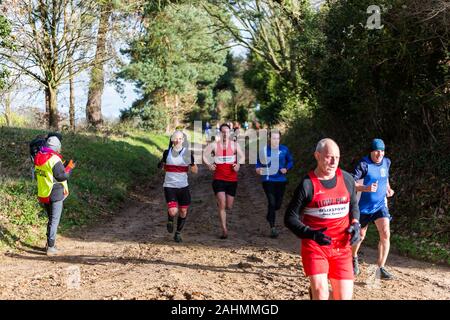 Sutton, Suffolk, VEREINIGTES KÖNIGREICH 15. Dezember 2019: eine Erwachsene über 18 cross country running Rennen durch einen schlammigen Landschaft Kurs Stockfoto