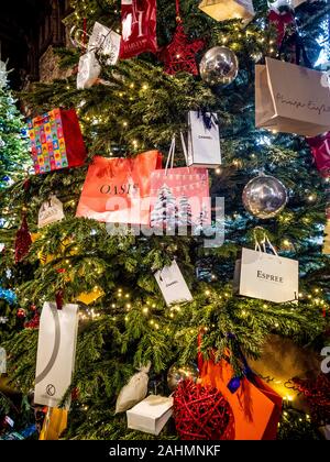 Einkaufstaschen mit Designer Markennamen auf Weihnachtsbaum gehängt. Stockfoto