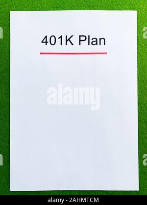 Papier mit 401k Plan auf grünem Hintergrund. Stockfoto