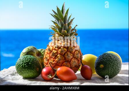 Tropische Früchte Sammlung, Custard Apple oder Grün reif cherymoia, Maracuja, Ananas, Mango, tamarillo, Avocado exotische Früchte auf blaues Meer hinterg Stockfoto