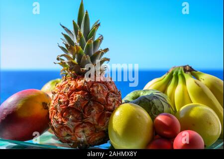 Tropische Früchte Sammlung, Custard Apple oder Grün reif cherymoia, Maracuja, Ananas, Mango, tamarillo, Bananen, exotische Früchte auf blaues Meer backgr Stockfoto