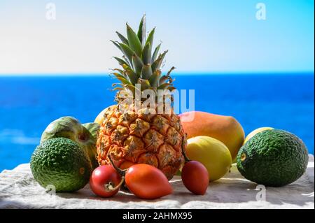 Tropische Früchte Sammlung, Custard Apple oder Grün reif cherymoia, Maracuja, Ananas, Mango, tamarillo, Avocado exotische Früchte auf blaues Meer hinterg Stockfoto