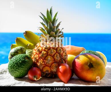 Tropische Früchte Sammlung, Custard Apple oder Grün reif cherymoia, Maracuja, Ananas, Mango, tamarillo, Avocado exotische Früchte auf blaues Meer hinterg Stockfoto