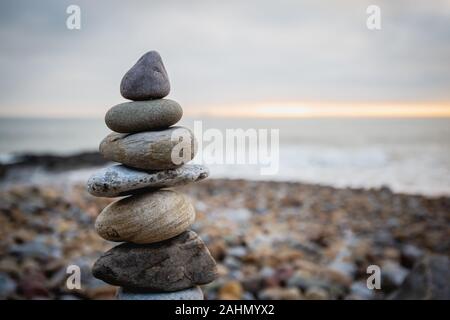 Stapel von Steinen gegen verwackelte an einem Strand swansea Wales, Platz für Text Seascape. Zen-Konzept Stockfoto