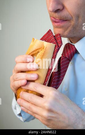 Menschen Essen einen Sandwich gemacht seine eigene Krawatte. Stockfoto