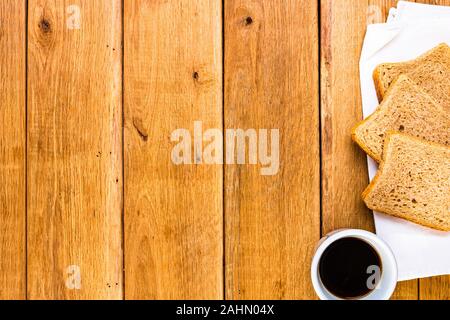Tasse Kaffee und Vollkorn Toast über Holz- Tabelle, Ansicht von oben, kopieren. Frühstück Konzept Stockfoto