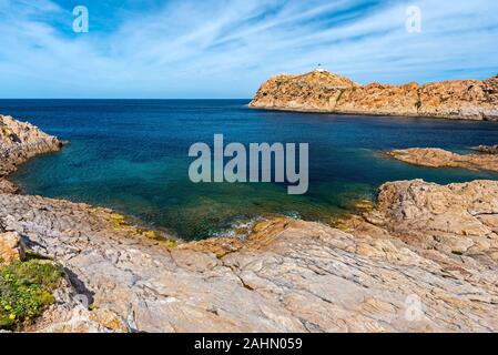 Küste Landschaft von Pietra Inselchen Ile-Rousse Stadt in Korsika gesehen, mit seinem Leuchtturm am Recht, rotem Porphyrstein Felsen Textur ist bei foregrond, H Stockfoto