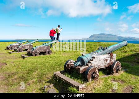 Tórshavn, Färöer - Juli 11, 2018 Touristische fotografieren Färöische Landschaft, historische Festung Skansin in Torshavn, alte Kanonen sind im Vordergrund Stockfoto