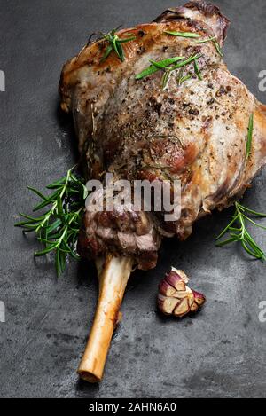 Ganze Lammbraten Bein auf dem schwarzen Stein Hintergrund Stockfoto