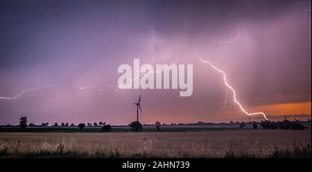 Schwere Gewitter bei Sonnenaufgang dargestellt, um eine Windenergieanlage Stockfoto