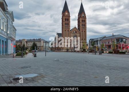 Szeged, Ungarn - 26. JULI 2019: Abend Blick der Twin überragte Unsere Liebe Frau von Ungarn Römisch-katholische Kirche mit dem neu gebauten Brunnen in der Stockfoto