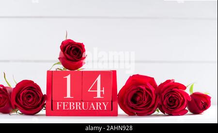 14. Februar, dem Valentinstag, Konzept. Februar 14 Buchstaben auf Holz- Kalender und Rosen auf Schreibtisch Stockfoto