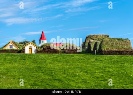 Traditionelle isländische Bauernhof Glaumbaer besteht aus Rasen Häuser im Norden von Island, als aus dem Süden Tür gesehen, oben auf der hölzernen Kirche ist hinter Stockfoto