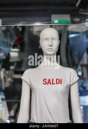 Mannequin in einem weißen T-Shirt mit der Aufschrift Saldi oder Verkauf im Fenster eines Clothing Store Stockfoto