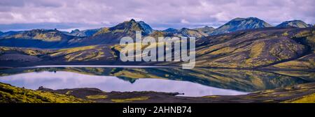 Panorama der Lambavatn See in Lakagigar vulkanischen Spalte, Lavaformationen, bedeckt mit gelb-grün Isländisch Moos im Wasser widerspiegelt. Süden Stockfoto