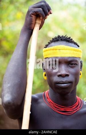 Porträt eines jungen Mannes aus der Mursi Stamm mit einem langen Stock, Omo Valley, südlichen Äthiopien, Äthiopien, Afrika Stockfoto