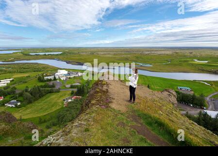 Mädchen teenager Aufnahme die Landschaft von Kirkjubaejarklaustur Dorf und den Fluss der Fluss im Skafta Skaftarhreppur Gemeinde im Süden von Island. Stockfoto