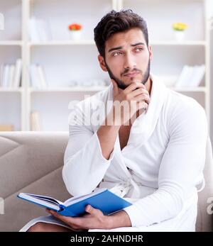 Junger Mann Student Geschäftsmann ein Buch lesen Studieren von zu Hause aus arbeiten Stockfoto